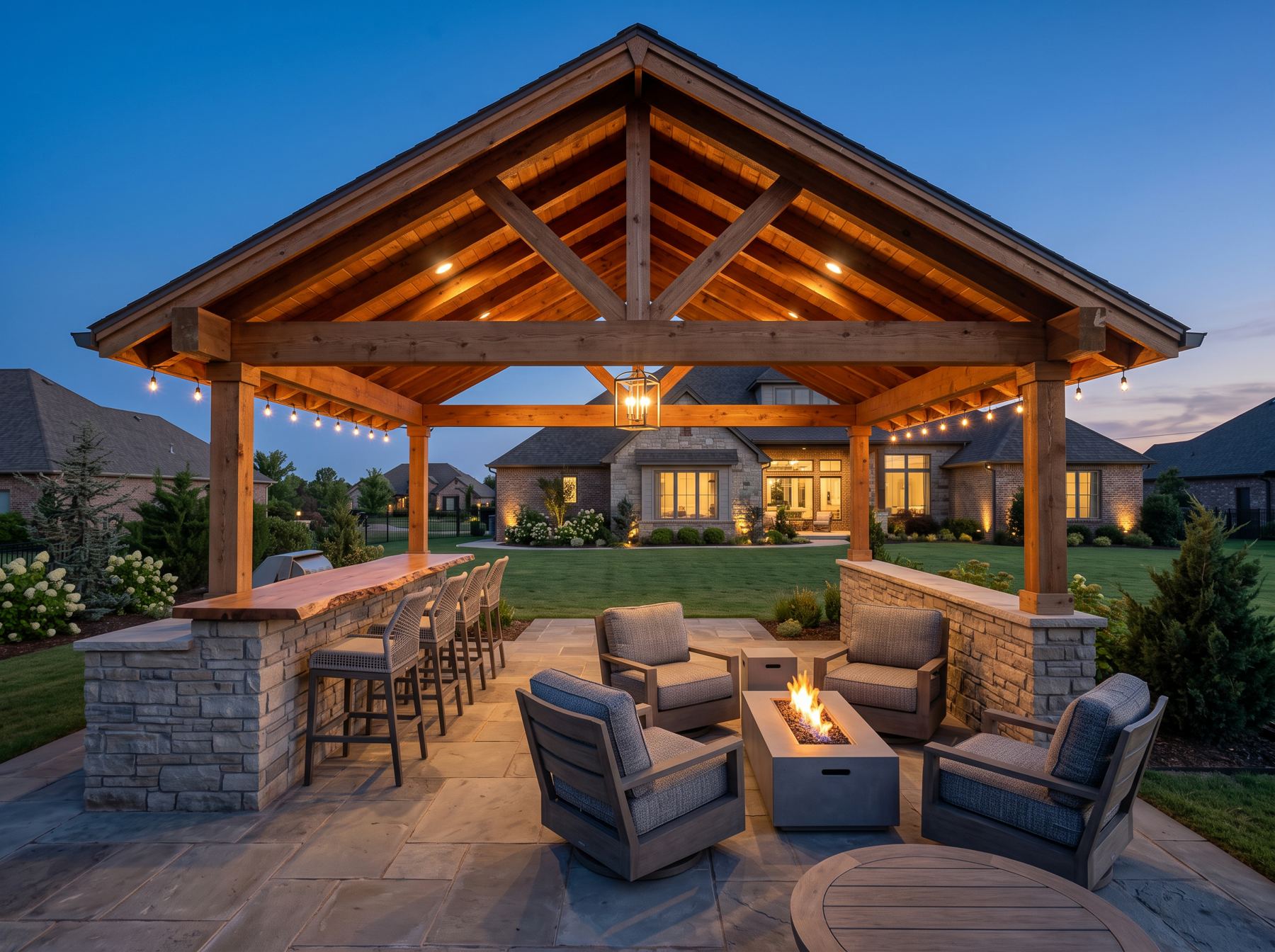 Detached backyard pavilion with cedar trusses, bar and fire table at dusk
